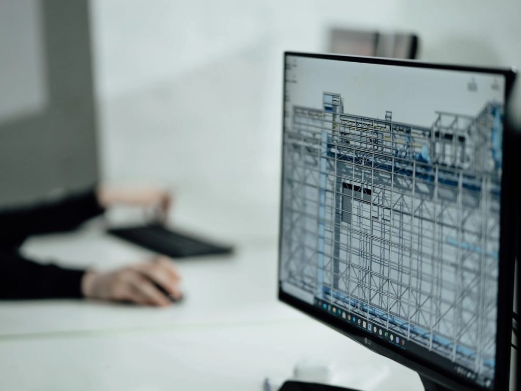 Architectural design model on a computer monitor in a professional studio workspace